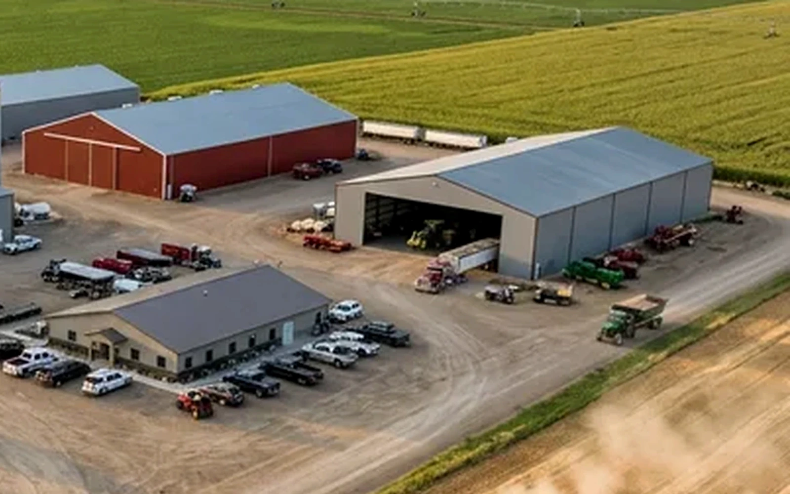 Großer landwirtschaftlicher Betriebsstandort mit Hallen, Feldern und Erntetechnik